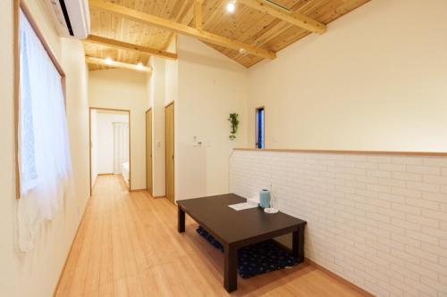 a room with a table and a brick wall at Tenjinbashi-suji Shopping Street Guesthouse Entire House Direct train access to 道頓堀 黒門市場 USJ Kansai International Airport in Osaka