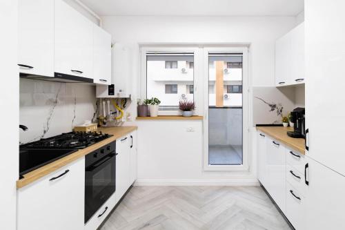 Popeşti-LeordeniにあるAmaria Sunsetの白いキッチン(白いキャビネット、コンロ付)