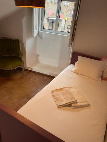 a bed in a room with a window and a chair at Casa de Unhais da Serra in Unhais da Serra