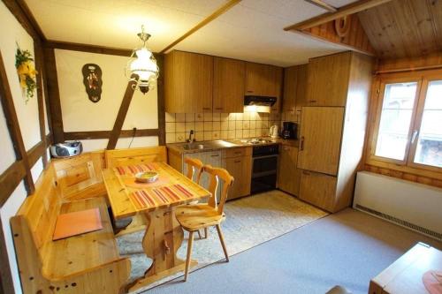 a kitchen with a wooden table and a dining room at Fewo Mit Blick Auf Die Berge in Sedrun