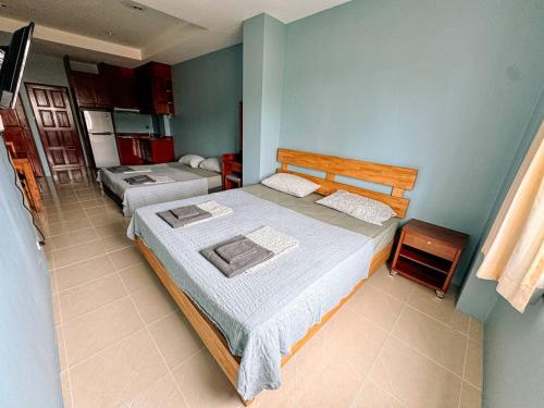 een slaapkamer met 2 bedden en een blauwe muur bij Orient Hotel in Jomtien Beach