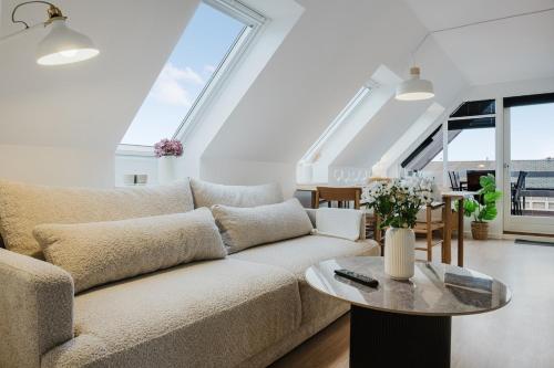 a living room with a couch and a table at Eksklusiv 2BR lejlighed I Terrasse I Fri parkering in Odense