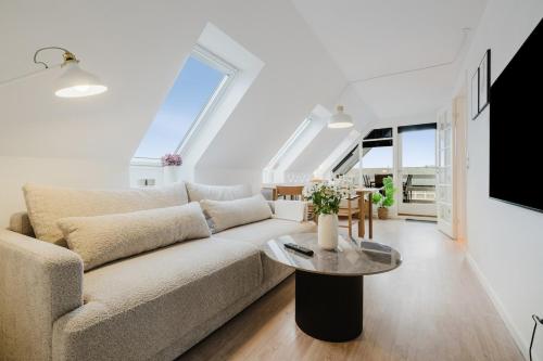 a living room with a couch and a table at Eksklusiv 2BR lejlighed I Terrasse I Fri parkering in Odense