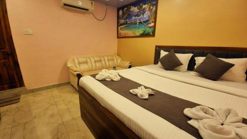 a hotel room with two beds with towels on them at Hotel Plaza in Chunchura