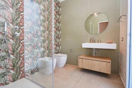 a bathroom with a toilet and a sink and a mirror at Villa the Twins in Castellammare del Golfo