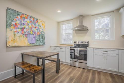 a kitchen with a painting of flowers on the wall at Classic City Apartment w Firepit in Athens
