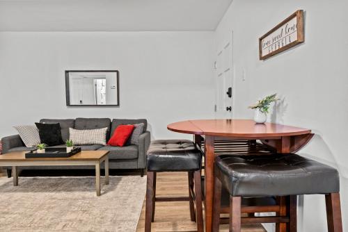 a living room with a table and a couch at Classic City Getaway - Walk to Sanford Stadium in Athens