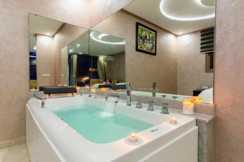 塔姆拉赫特乌兹达尔MoonLight Duplex Sea & Comfort的一间带大镜子和浴缸的浴室