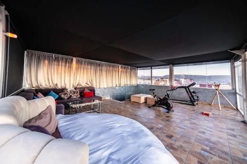 塔姆拉赫特乌兹达尔MoonLight Duplex Sea & Comfort的宽敞的客厅里有沙发和健身房