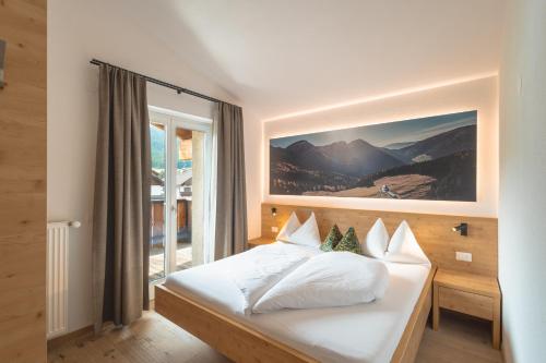 a bedroom with a bed with a large window at Kriendl Nr 4 in Valdaora
