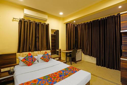 a bedroom with two beds and a desk and a window at FabHotel Club Metro in Nagpur