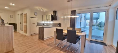 een keuken en eetkamer met een tafel en stoelen bij StrandGut inkl Saisonstrandkorb und Wäsche Set in Heiligenhafen