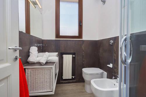une salle de bains avec toilettes, lavabo et miroir dans l'établissement Villa Tarì, à Scopello