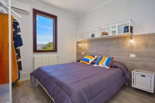 une chambre avec un grand lit violet avec deux oreillers dans l'établissement Villa Tarì, à Scopello