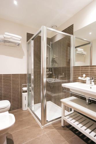 a bathroom with a shower and a toilet and a sink at Hotel Il Cervo, SPA & Wellness, Bike Hotel in Tarvisio