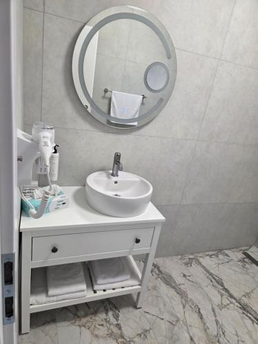a bathroom with a white sink and a mirror at FLORA Garden Relax in Filiaşi
