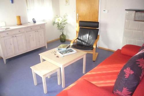 a living room with a red couch and a table at Ferienhaus Buschle in Tettnang