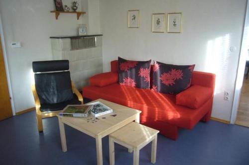 a living room with a red couch and a table at Ferienhaus Buschle in Tettnang