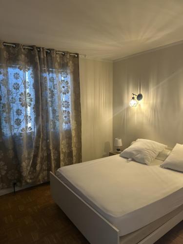 a bedroom with a large white bed with a window at La Maison de Campagne in Estalane