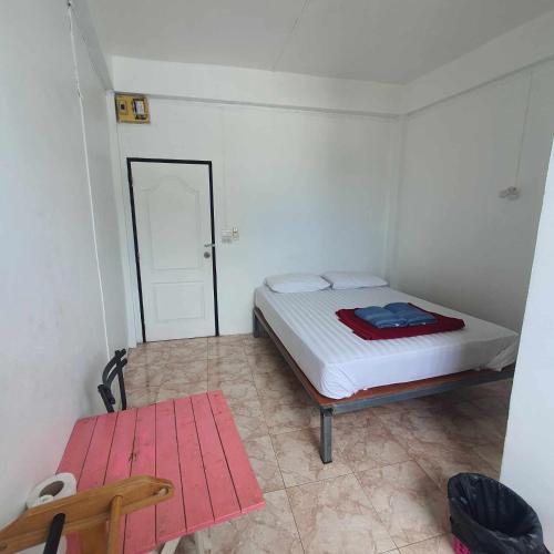 a bedroom with a bed and a table and a door at 8 homestel in Ko Tao