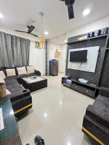 a living room with a couch and a flat screen tv at Night View Apartment in Ghaziabad