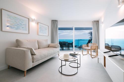 ein Wohnzimmer mit Couch und Blick aufs Meer in der Unterkunft Blue Balcony Suites by Airnest in Melenara