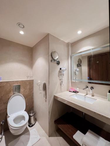 a bathroom with a toilet and a sink at Tulip Inn Bhopal in Bhopal