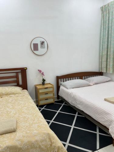 two beds sitting next to each other in a bedroom at Magnolia 3 Homestay in Kampung Raja