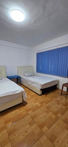 - une chambre avec 2 lits et une fenêtre bleue dans l'établissement Indian Valley Guest House, à Sihanoukville