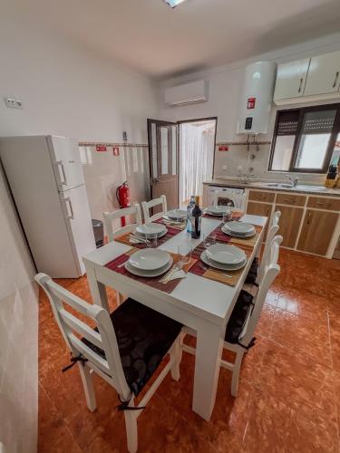 a kitchen with a white table and chairs in a room at Casa Passa Tempo in Aldeia do Mato