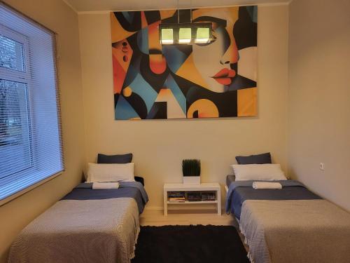 two beds in a room with a painting on the wall at Aste loft in Aste