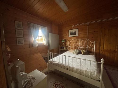 a bedroom with a bed in a wooden cabin at Villa Sillankorva in Viitasaari
