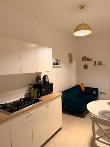 een keuken met een fornuis en een blauwe bank bij Casetta Martesana in Milaan