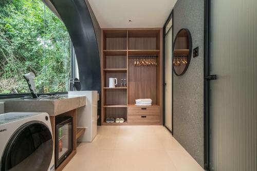 een wasruimte met een wastafel en een wasmachine bij Karst Scenic Hotel in Gaotian