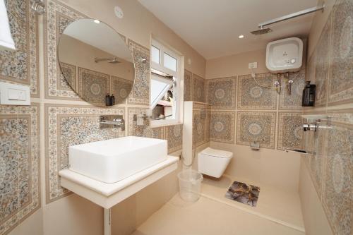 a bathroom with a sink and a mirror and a toilet at PENANG Home Away From Home in Darjeeling