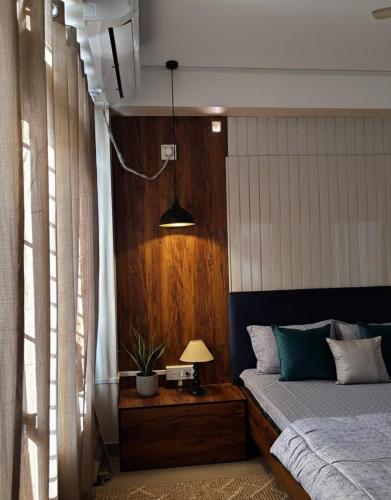 een slaapkamer met een bed en een tafel met een lamp bij PANAH luxe in Guwahati