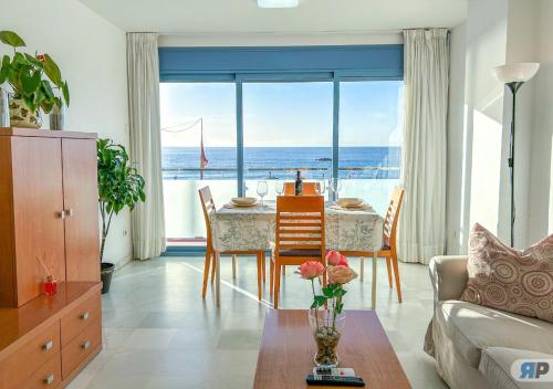 ein Wohnzimmer mit Tisch und Blick auf das Meer in der Unterkunft Apartamentos Varadero Sea View in La Cala del Moral