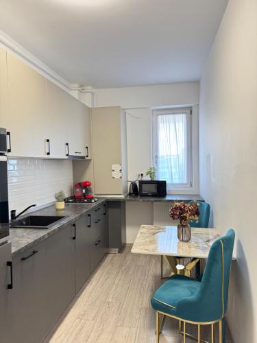 ヤシにあるLuxury Collection Studios at Q Residence Palas Mallのキッチン(テーブル、青い椅子付)