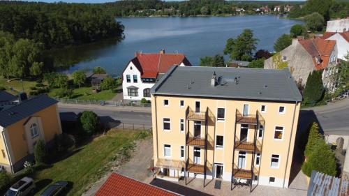 an aerial view of a large yellow building with a lake at Alt-Berliner Schwanenhof Ferienwohnung OG links in Lychen