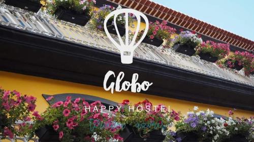 a sign on the side of a building with flowers at Globo Happy Hostel in Angra do Heroísmo