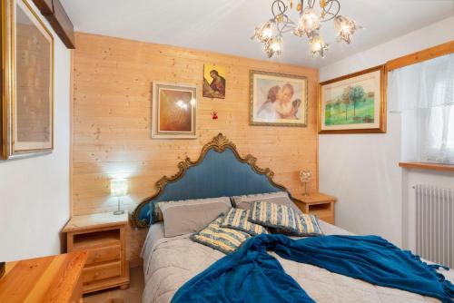 een slaapkamer met een bed met een blauw hoofdeinde bij Ciasa La Cate in Bellamonte