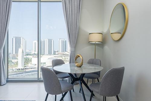 a dining room with a table and chairs and a mirror at Urban Chic - Shams Meera in Abu Dhabi