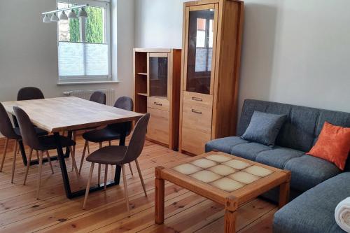 un salon avec une table et un canapé dans l'établissement Alt-Berliner Schwanenhof Ferienwohnung EG rechts, à Lychen