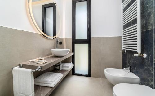 a bathroom with a sink and a toilet and a mirror at Residence Cala Vela Tower in Riccione