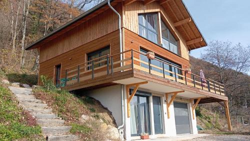 a wooden house with a balcony on a hill at Chalet vue panoramique in Fillinges