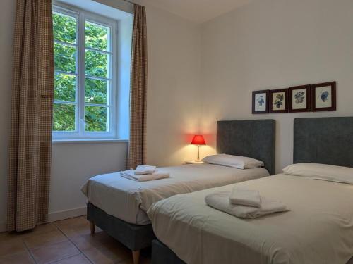 ein Schlafzimmer mit zwei Betten und einem Fenster in der Unterkunft Gîte familial avec piscine chauffée, jardin clos, équipement bébé, au cœur d'une propriété viticole. - FR-1-653-70 in Saint-Cybardeaux
