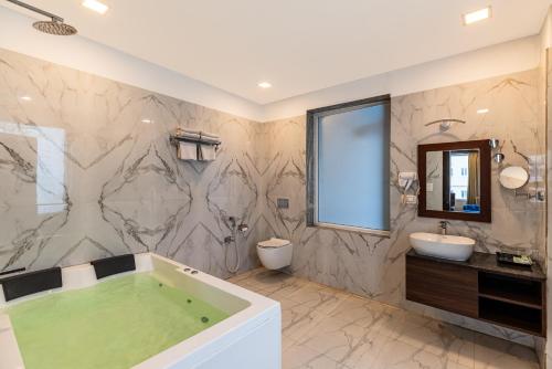 un baño con bañera y lavabo en The Colonial - A Lake View Hotel in Udaipur, en Udaipur