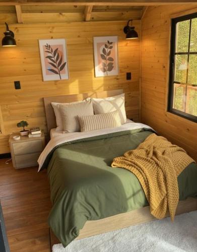 a bedroom with a large bed in a wooden wall at Casa del Árbol Sesquile in Tres Esquinas