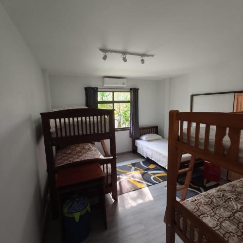 a room with two bunk beds and a window at MATA Garden resort Ao Nang in Ao Nang Beach