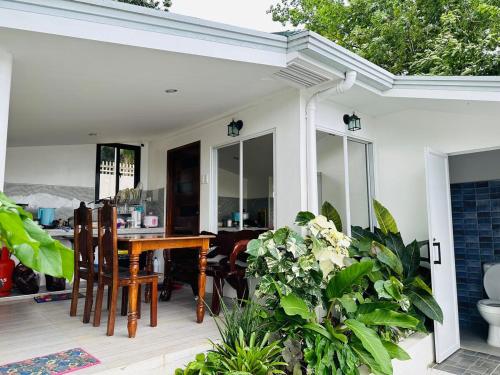 a patio with a wooden table and some plants at Cozy Skyview Villa in Lopez Quezon! in Lopez